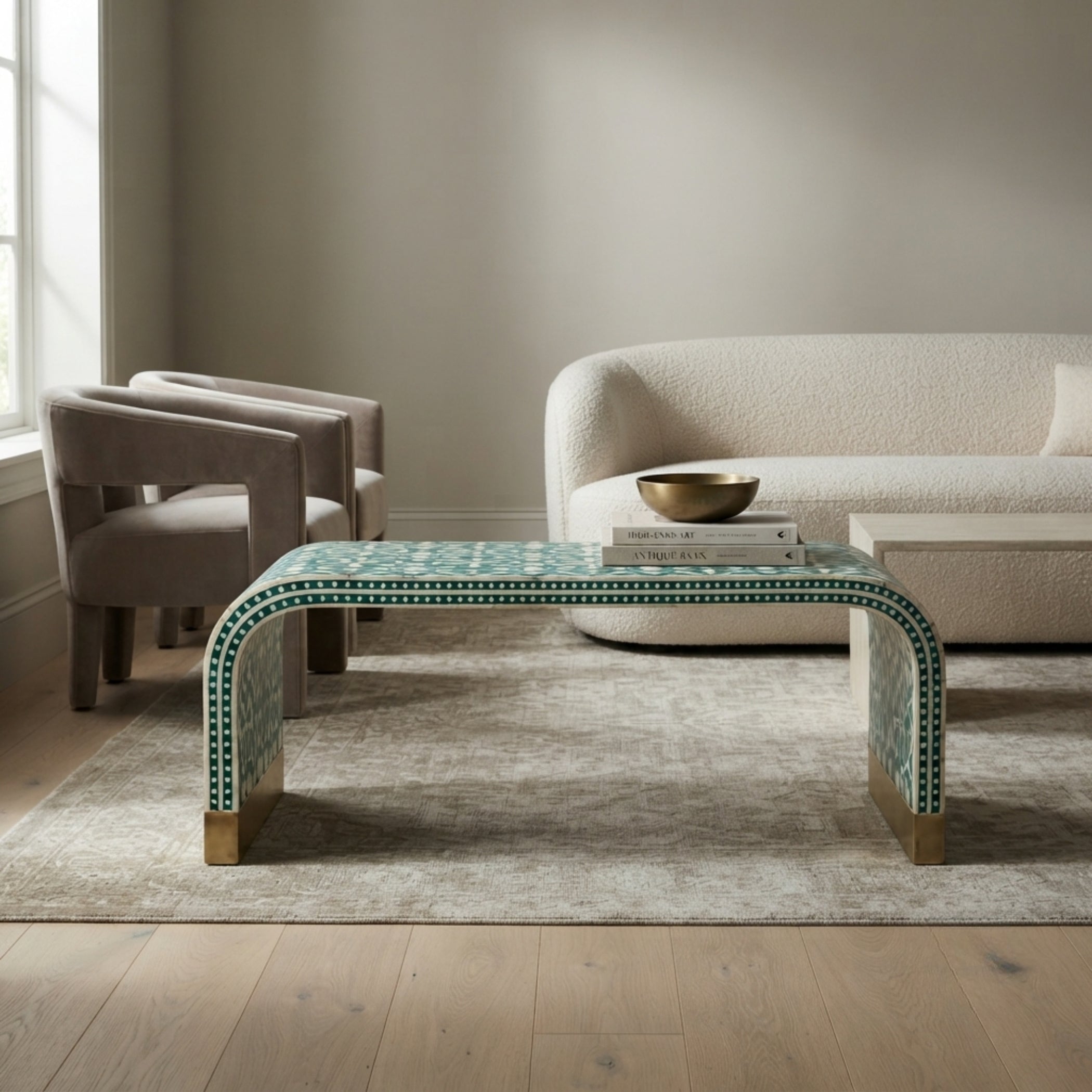 A modern curved coffee table with a green and white geometric mosaic tile pattern and gold-toned legs, styled in a contemporary living room setting.