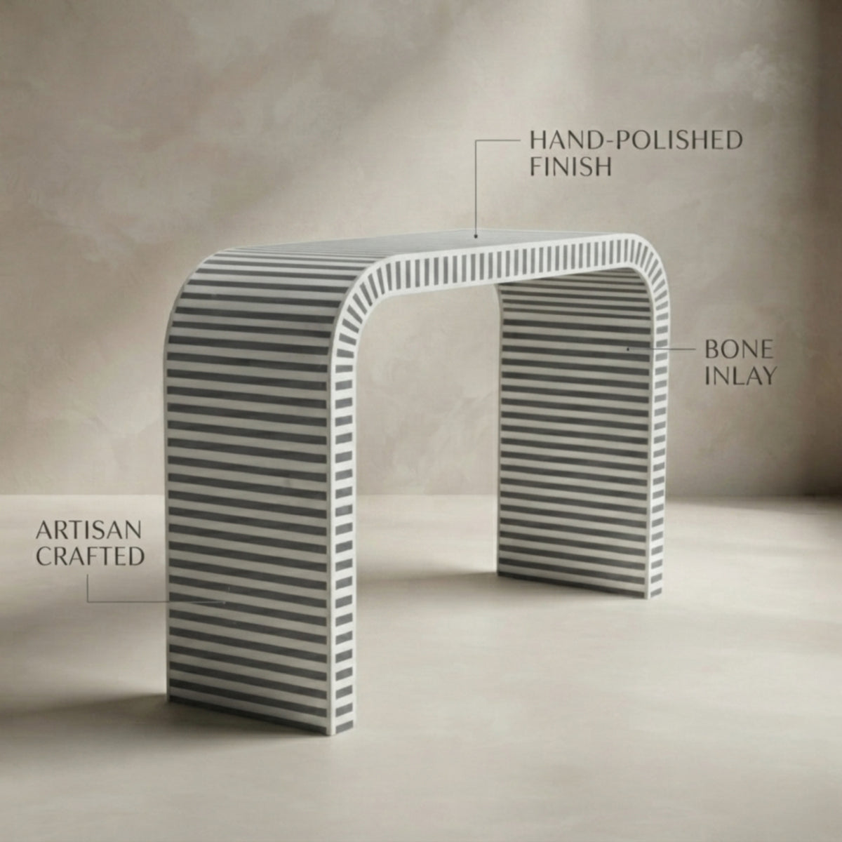 A modern curved table with a striped bone inlay pattern, shown with text callouts reading 'HAND-POLISHED FINISH', 'BONE INLAY', and 'ARTISAN CRAFTED' against a neutral beige background.