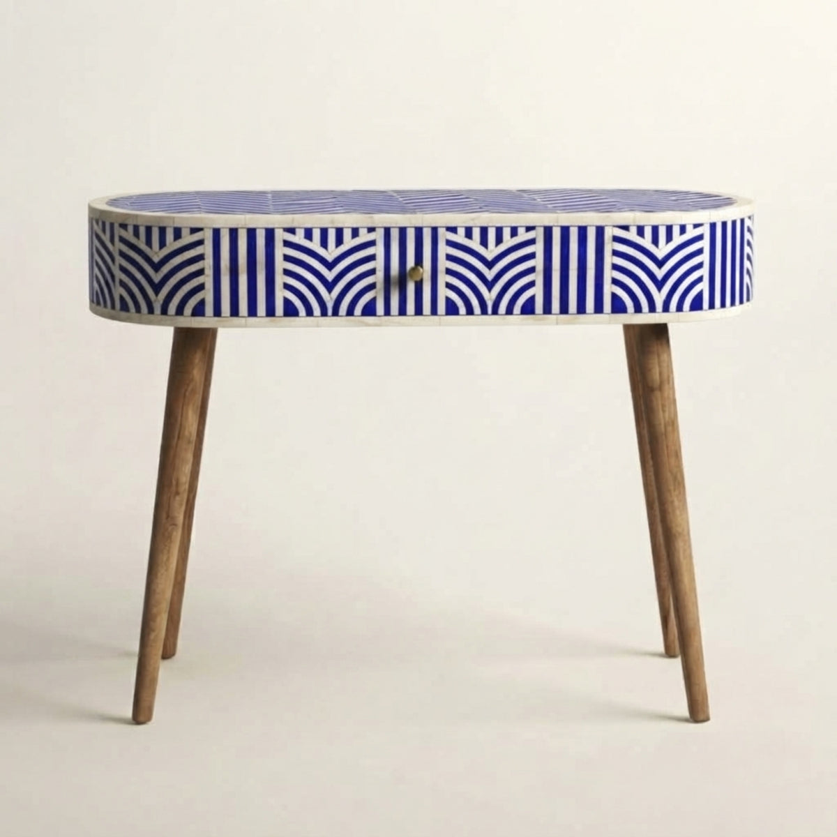 An oval console table with a blue and white geometric patterned bone inlay frame and natural wood legs, shown against a plain off-white background.