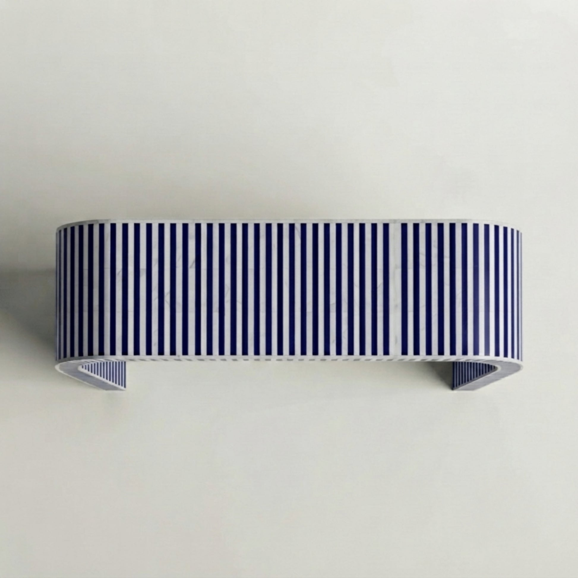 A modern wall-mounted shelf with a bold navy blue and white vertical stripe pattern, shown against a plain off-white wall.