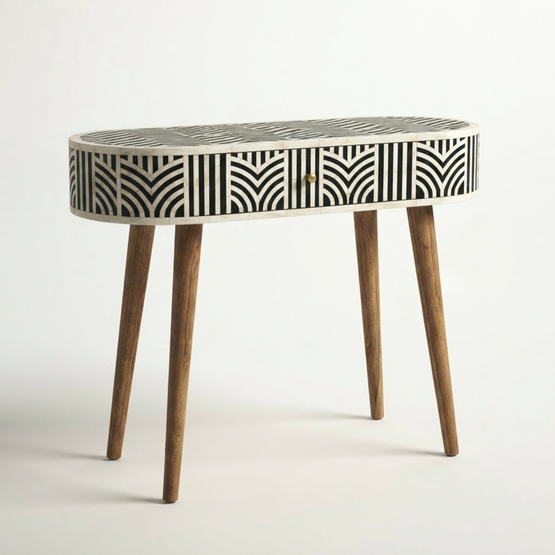 An oval console table featuring a black and white geometric bone-inlay pattern on the drawer front, with a white frame and four tapered wooden legs.