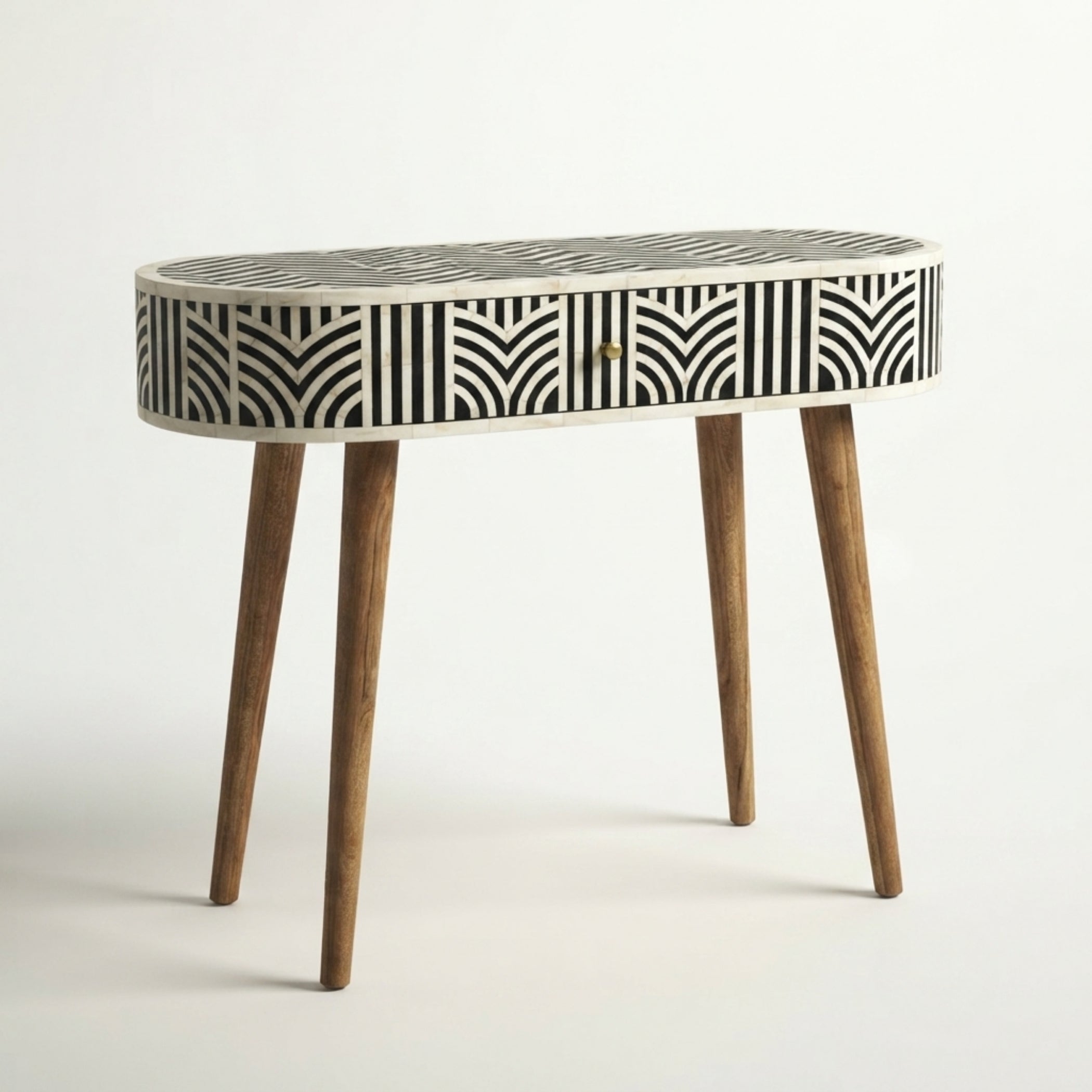 An oval console table featuring a black and white geometric bone-inlay pattern on the drawer front, with a white frame and four tapered wooden legs.