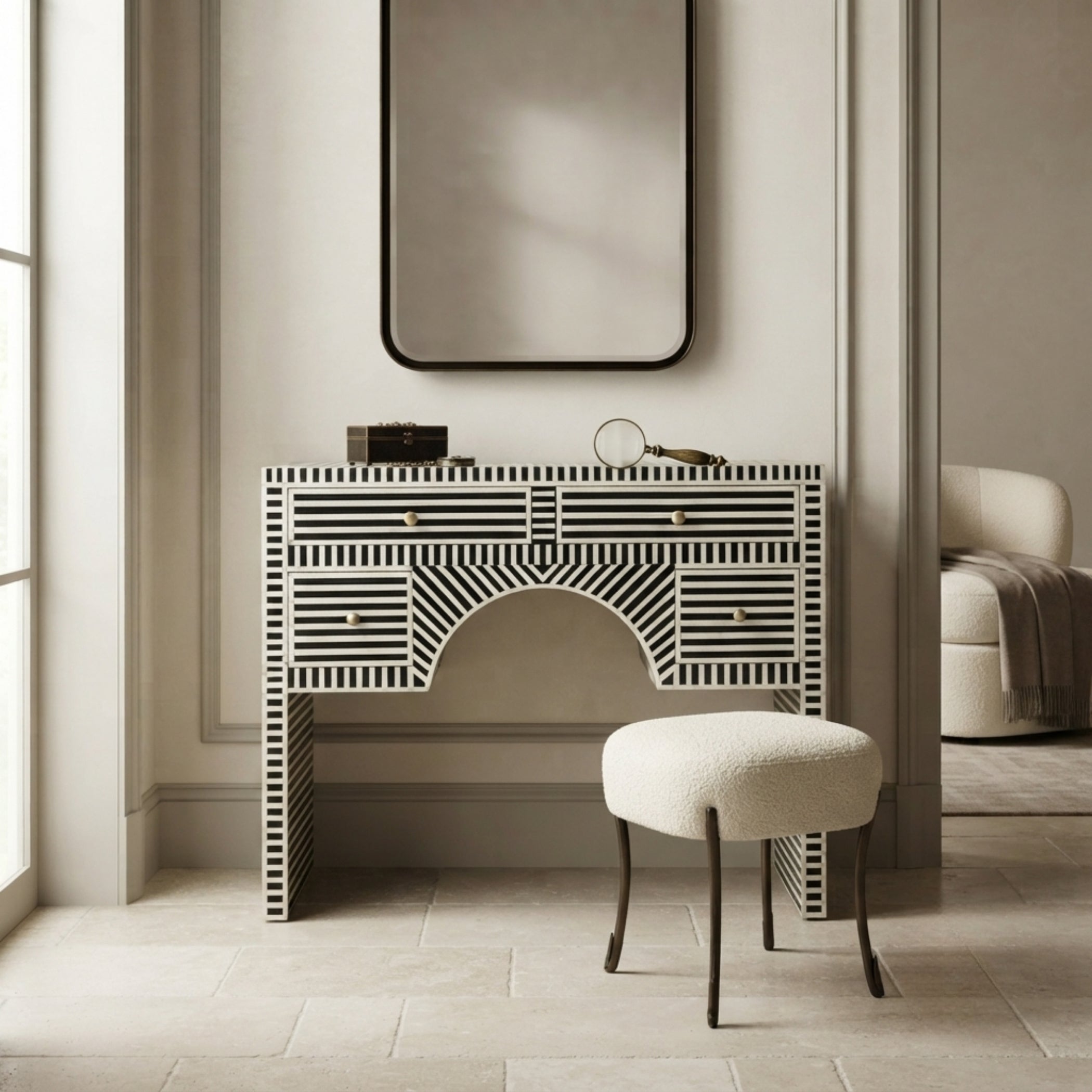 A black and white striped bone-inlay console table with a matching upholstered stool in a neutral-toned, elegant room.