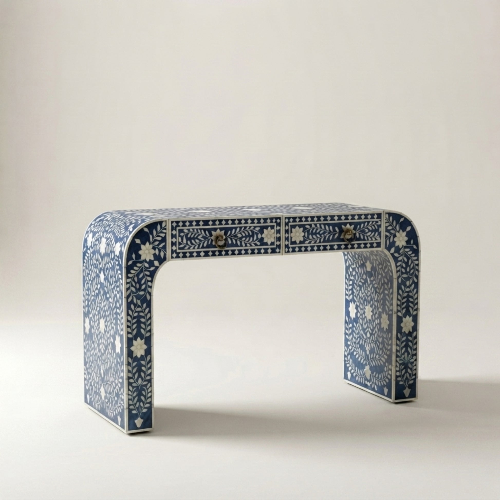 A blue and white bone-inlay console table with two drawers and curved legs, photographed against a neutral light beige background.