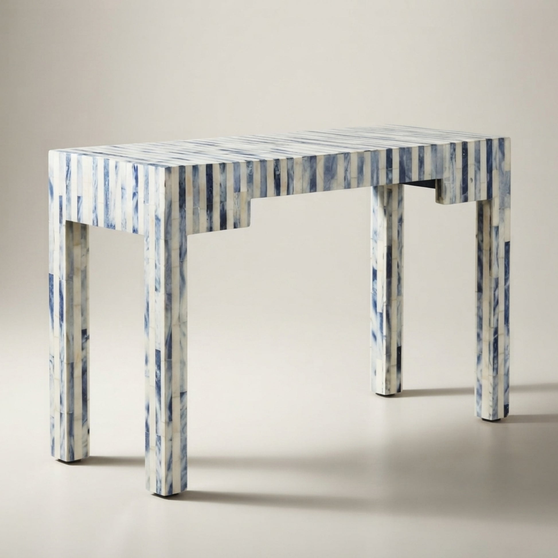 A rectangular console table with a blue and white vertically striped pattern, shown on a neutral light gray studio background.