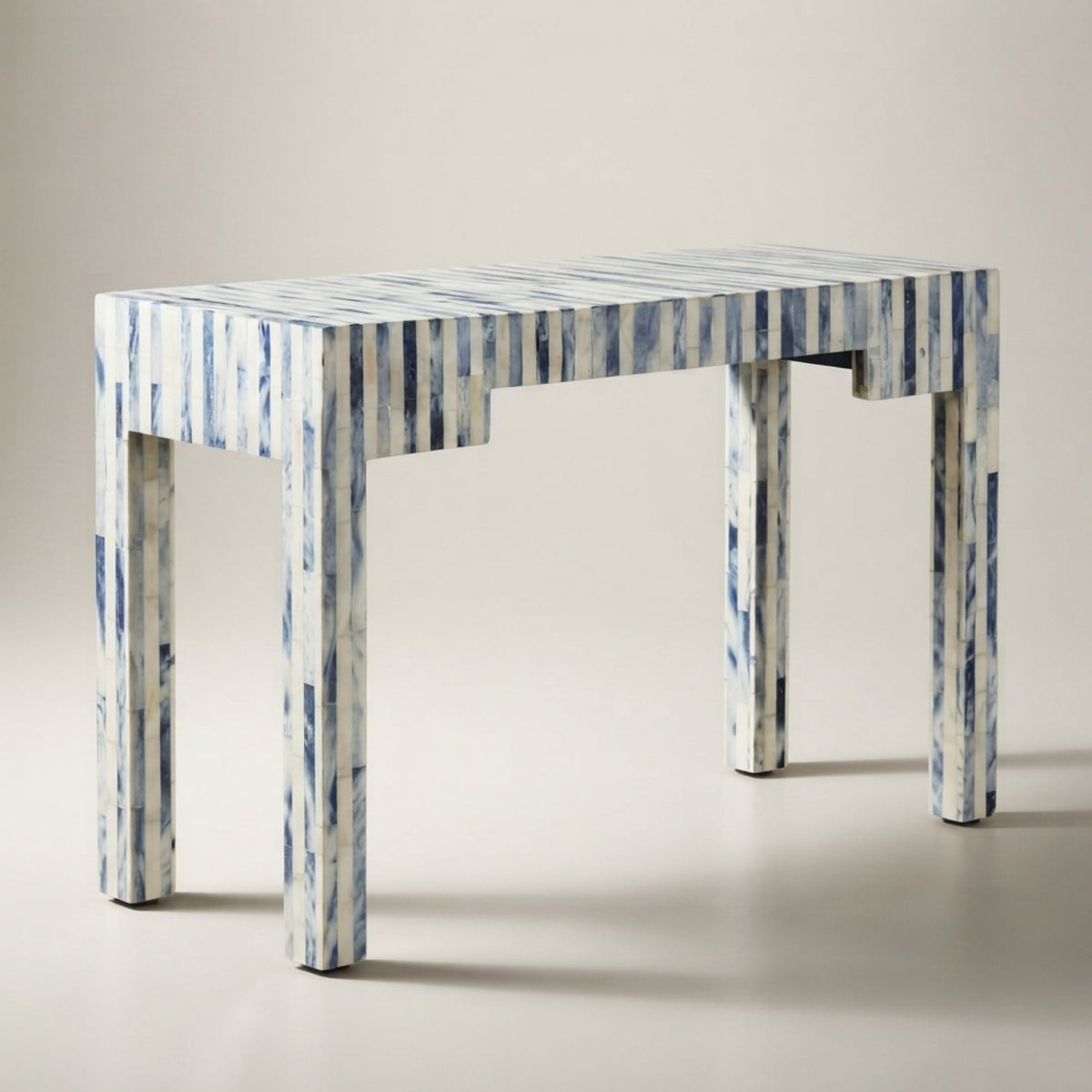 A rectangular console table with a blue and white vertically striped pattern, shown on a neutral light gray studio background.