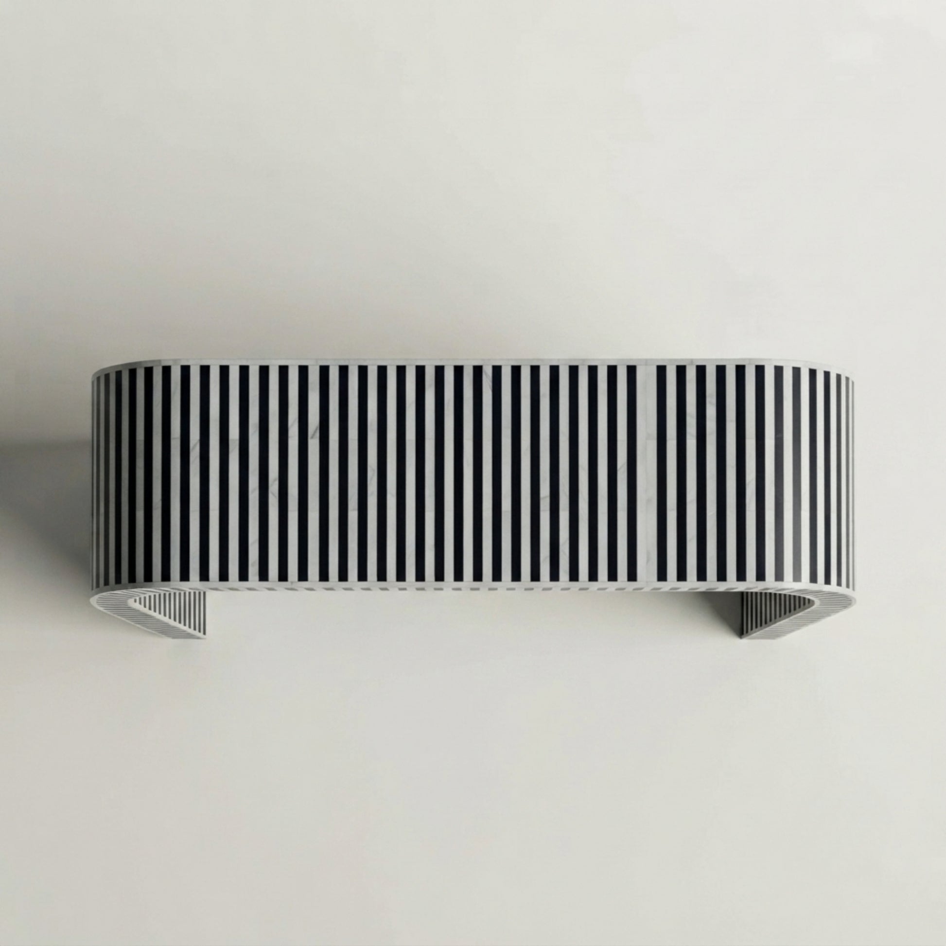 A modern wall-mounted shelf with a bold black and white vertical striped pattern, shown against a plain light gray wall.