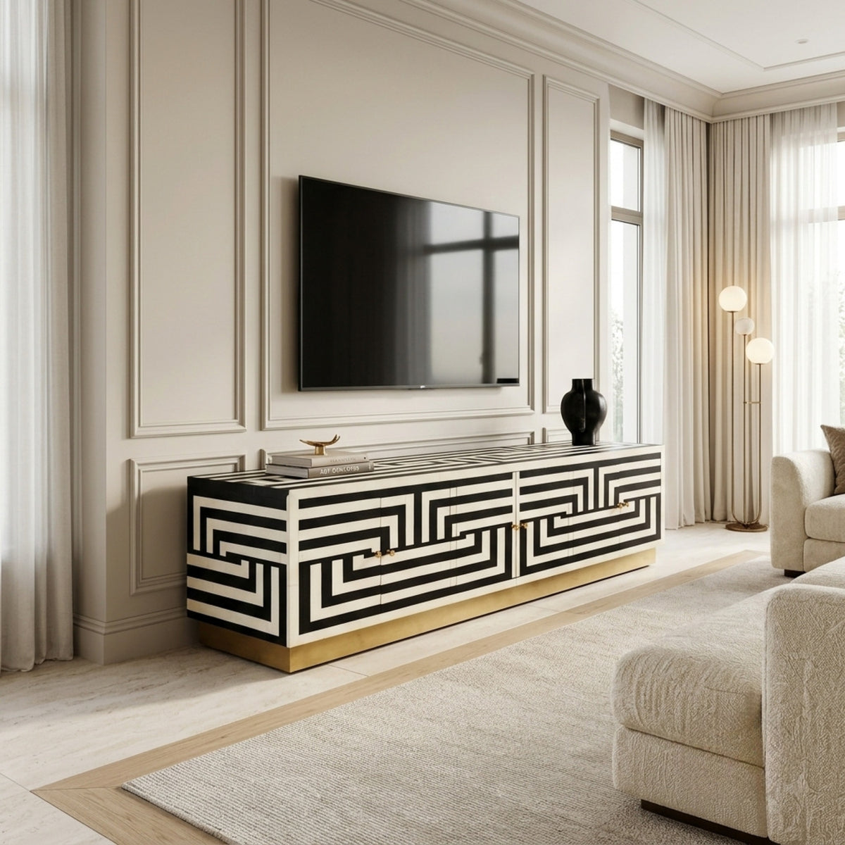 A modern media console in a living room setting, featuring a bold black and white geometric pattern with a gold base, styled under a wall-mounted flat-screen TV.