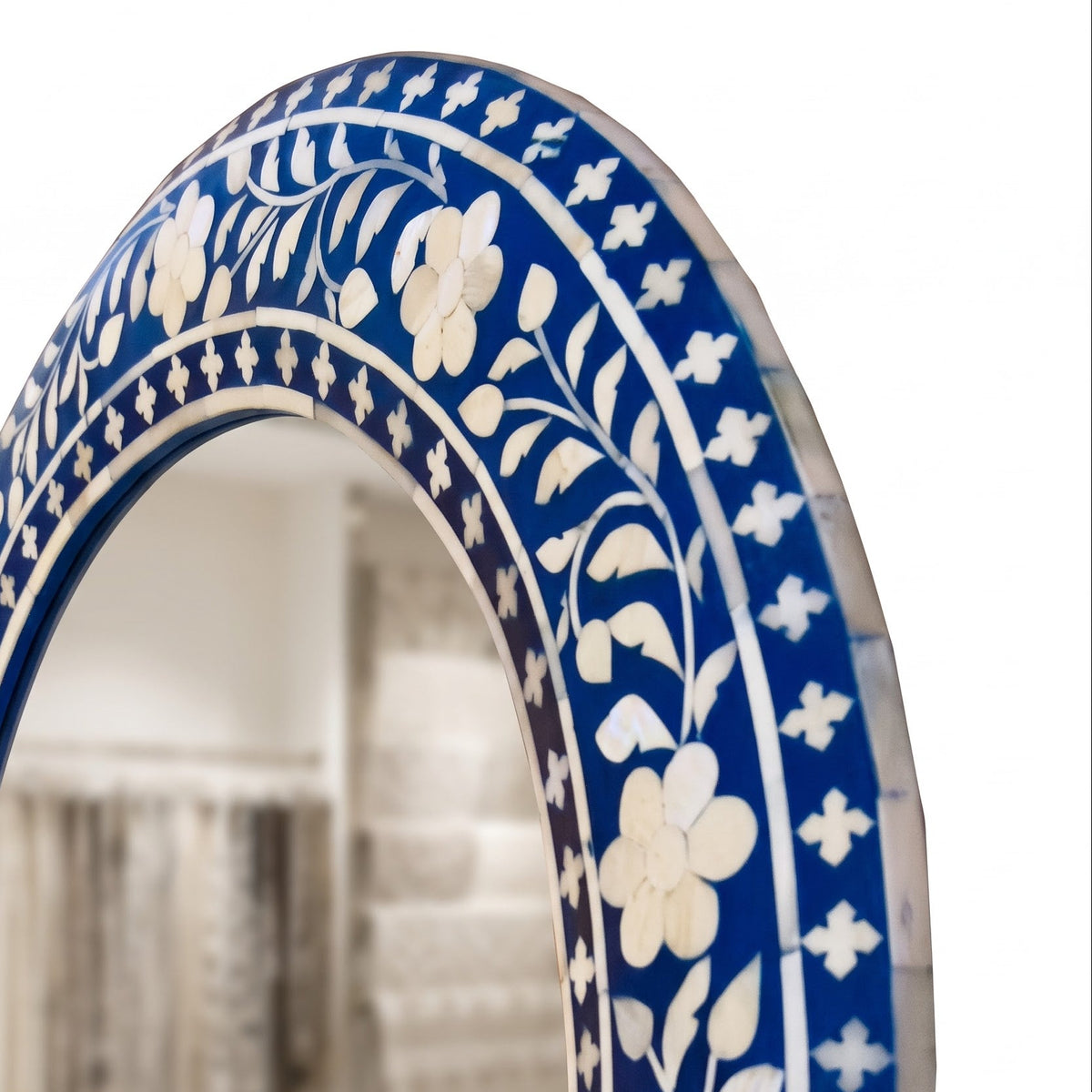 An arched wall mirror with a richly decorated blue and white inlay border featuring floral and geometric patterns, shown against a white background.