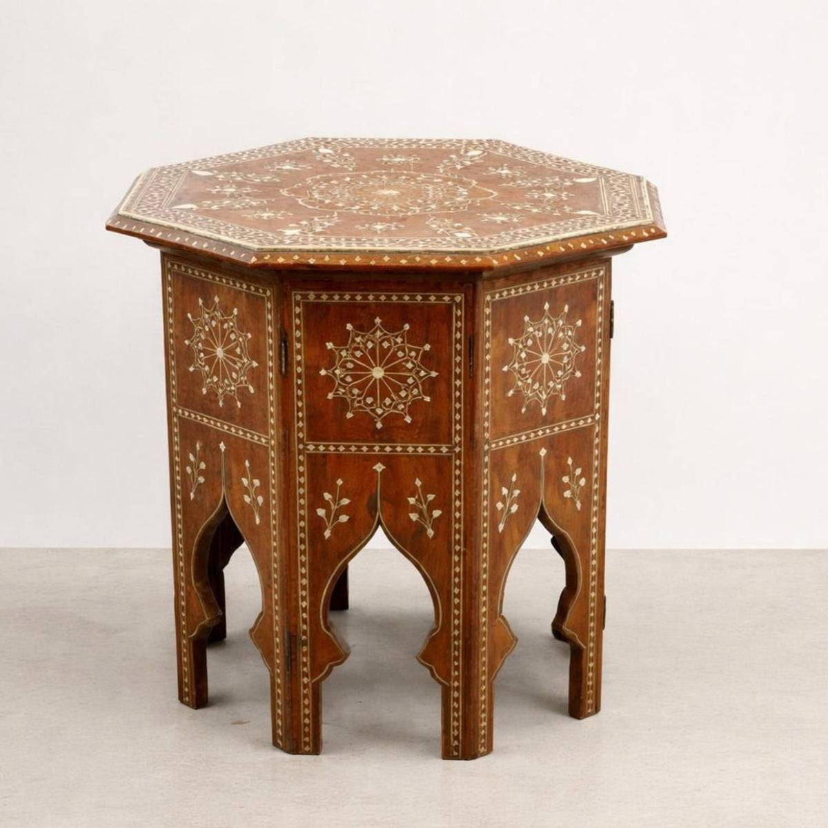 An octagonal wooden side table with intricate cream-colored inlay patterns on a medium brown wood finish, set against a plain light gray background.