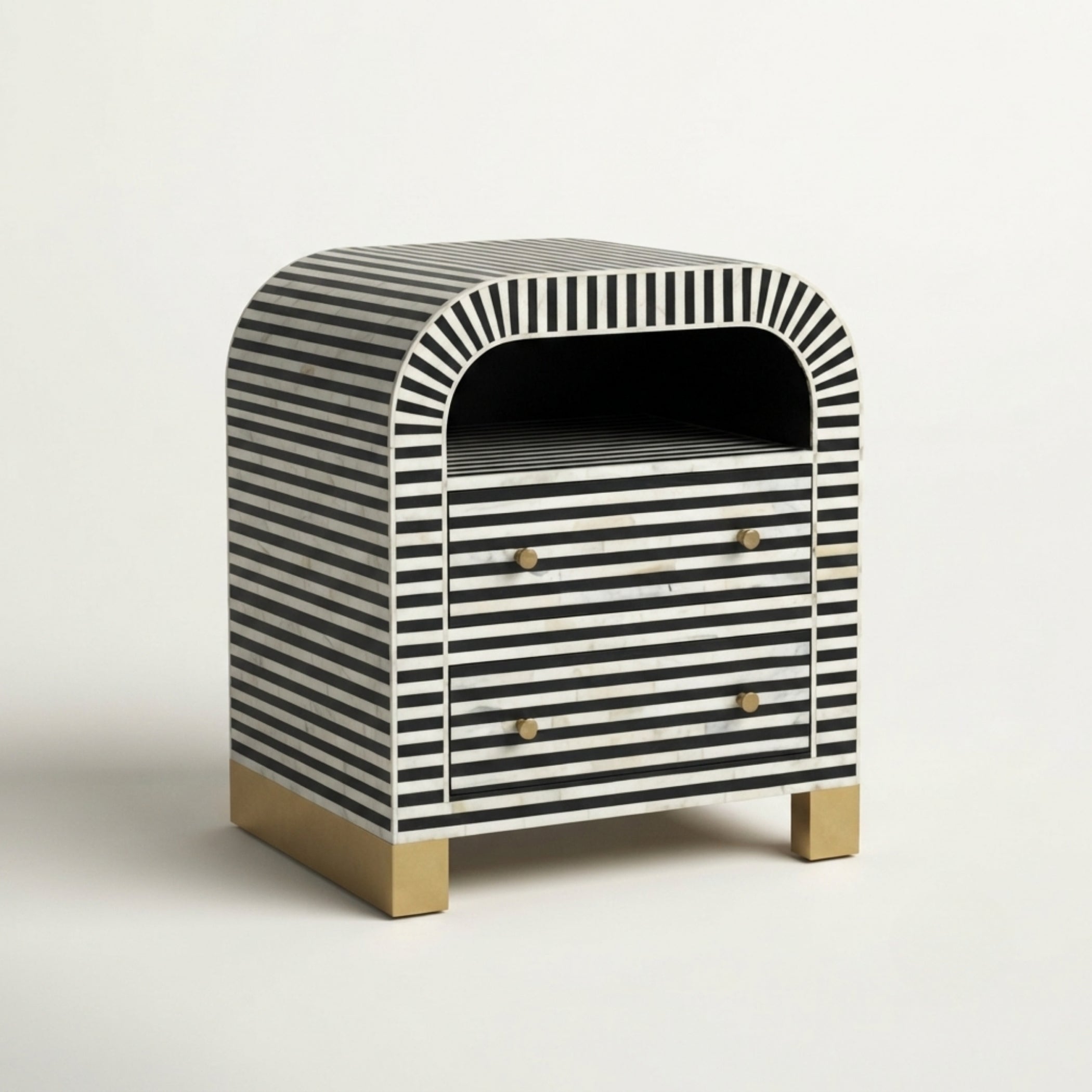 A small two-drawer nightstand with a black and white striped bone-in-lay finish, featuring a rounded top, brass drawer knobs, and a brass block base, photographed on a clean white background.