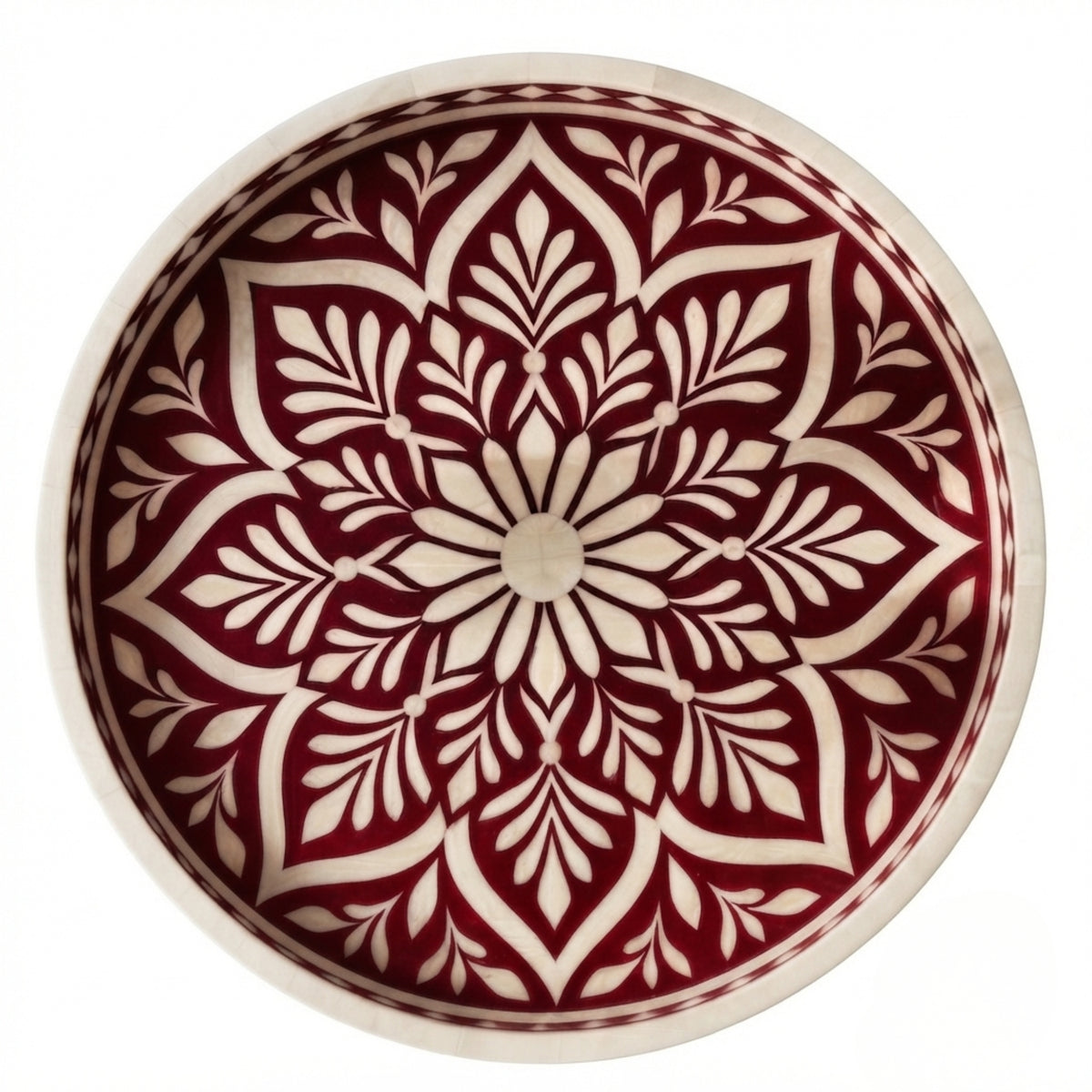 A round ceramic bowl with a hand-painted red and cream mandala pattern, photographed from directly above on a white background.