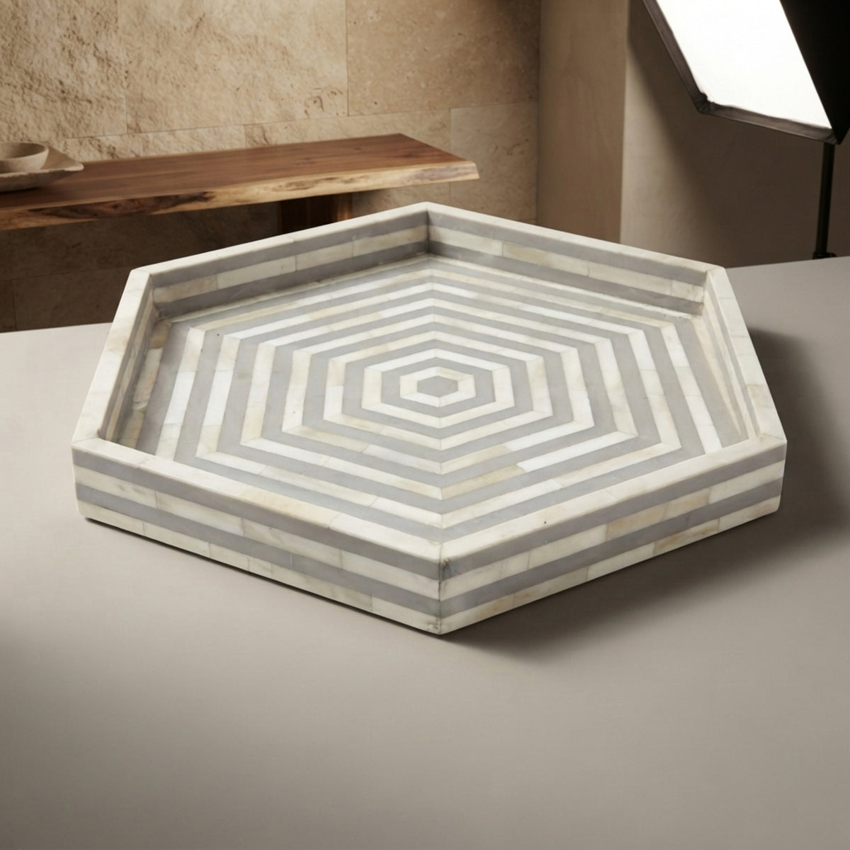 Hexagonal bone-inlay serving tray with concentric geometric patterns in white and gray, displayed on a neutral surface.