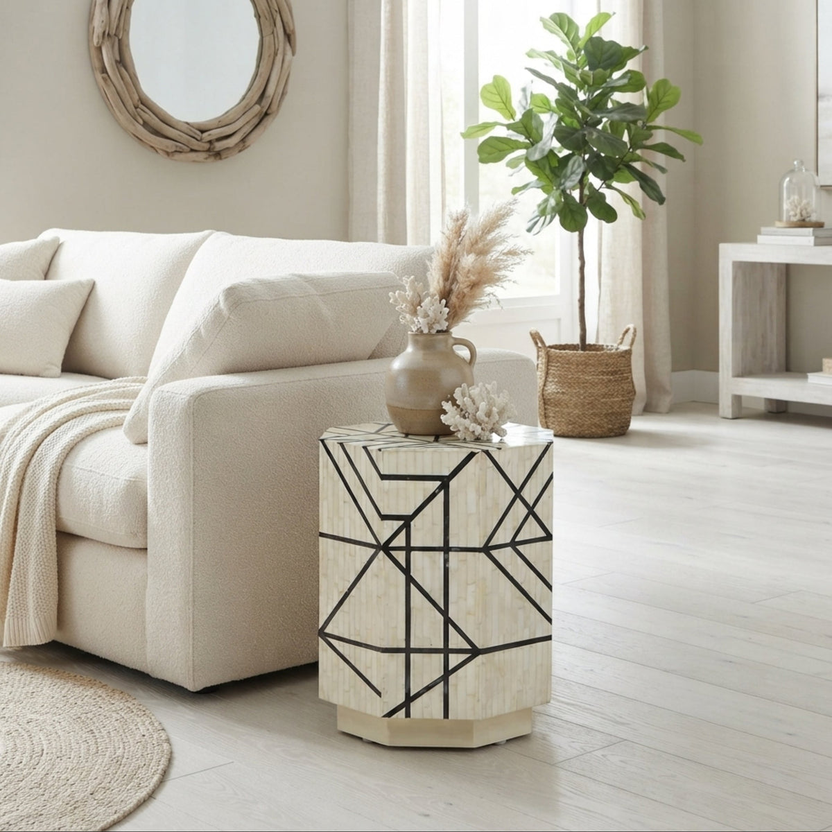 A modern octagonal side table with a cream-colored shell or wood geometric pattern and black lines, styled in a bright, neutral-toned living room next to a cream sofa.