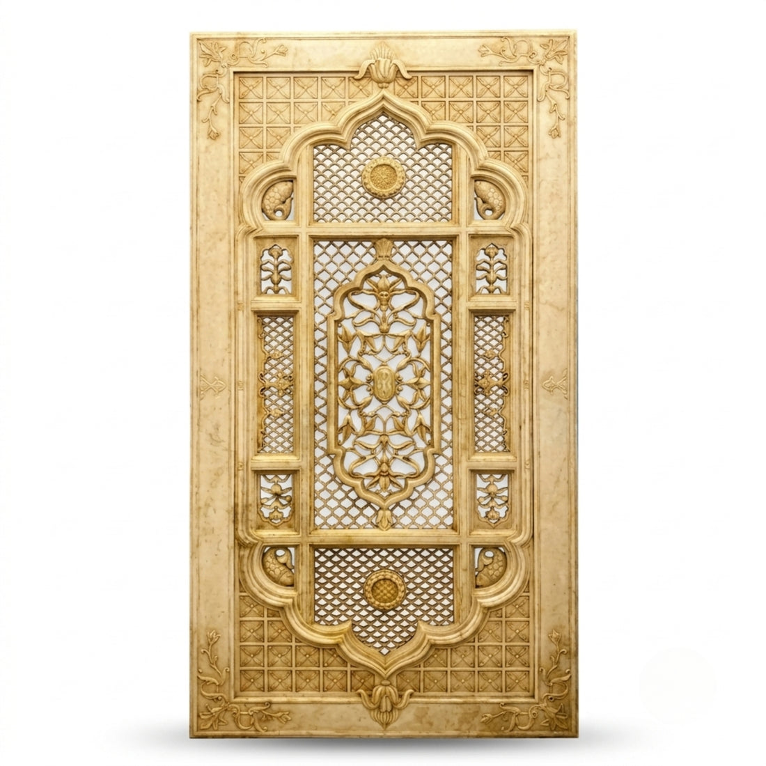 An ornate vertical decorative panel with intricate geometric and floral carvings in warm beige and gold tones, shown hanging on a textured beige wall beside a curtain and sofa.