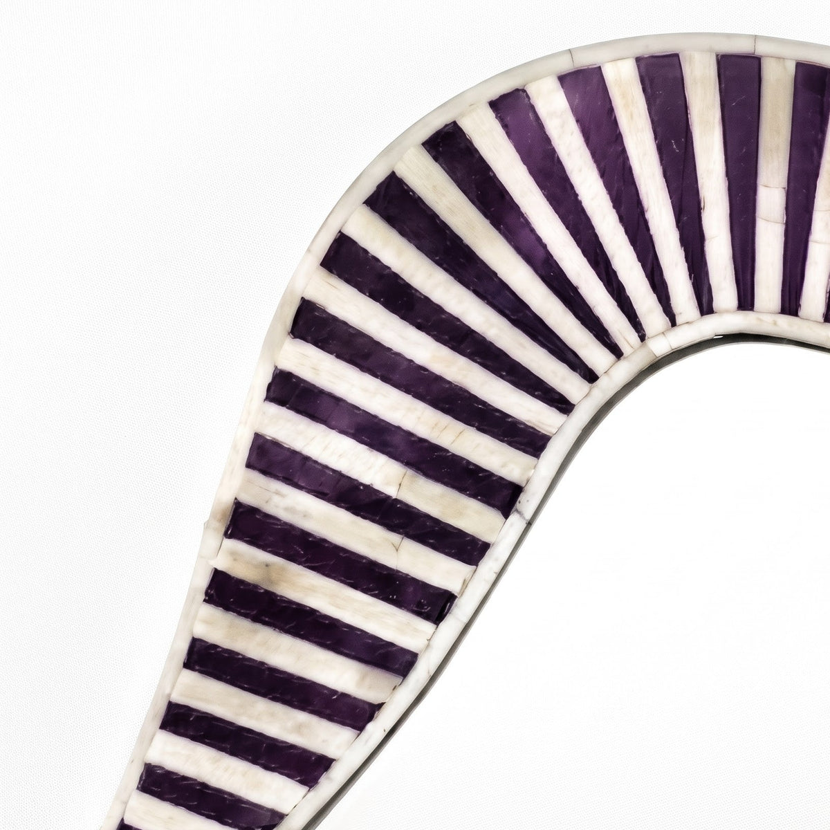 A close-up of a curved object featuring a striped pattern of dark purple and off-white segments, set against a plain white background.