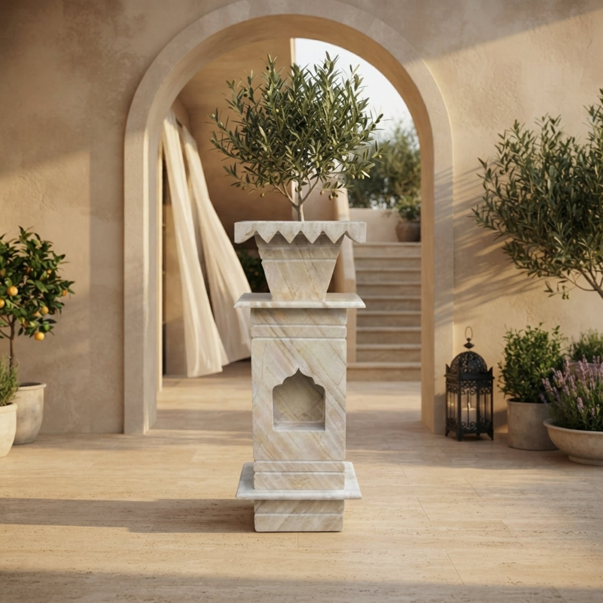 A tall marble planter stand holding a potted olive tree, set in a sunlit Mediterranean-style courtyard with arches, potted plants, and a lantern.