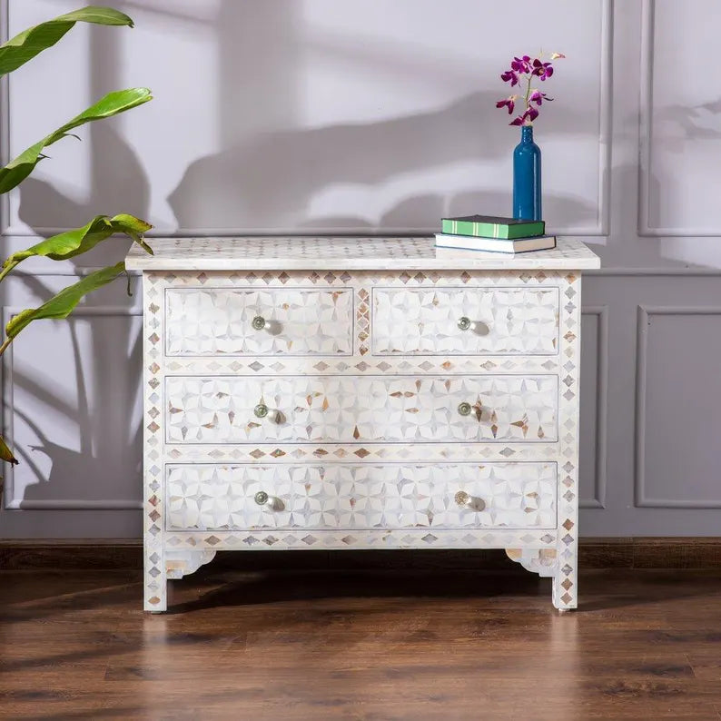 Decorative chest of drawers with shell inlay in a room setting.
