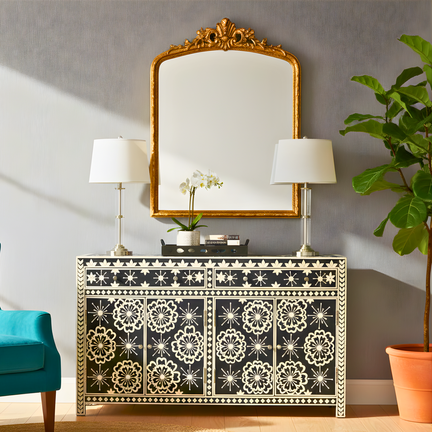 Decorative console table with floral patterns, gold-framed mirror, and lamps in a room setting.