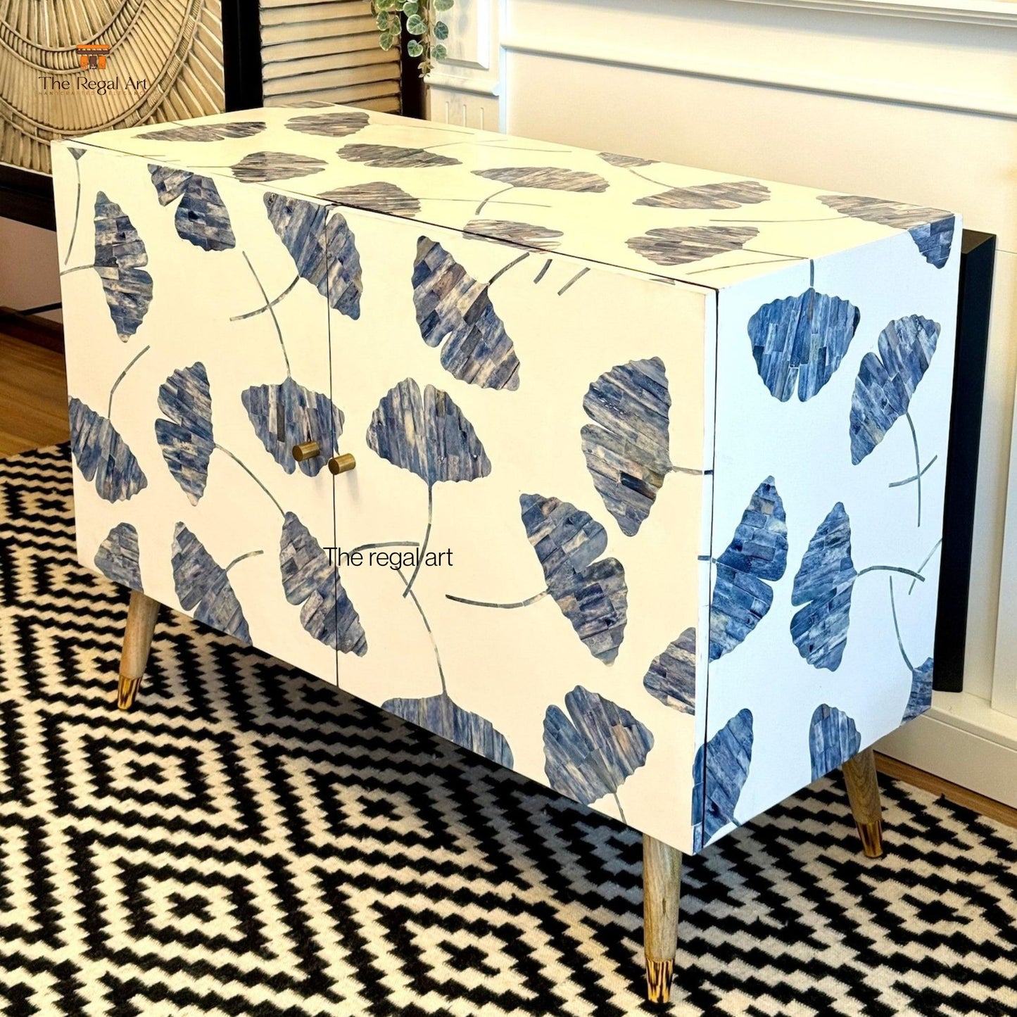 Cabinet with blue leaf pattern on a black and white geometric rug