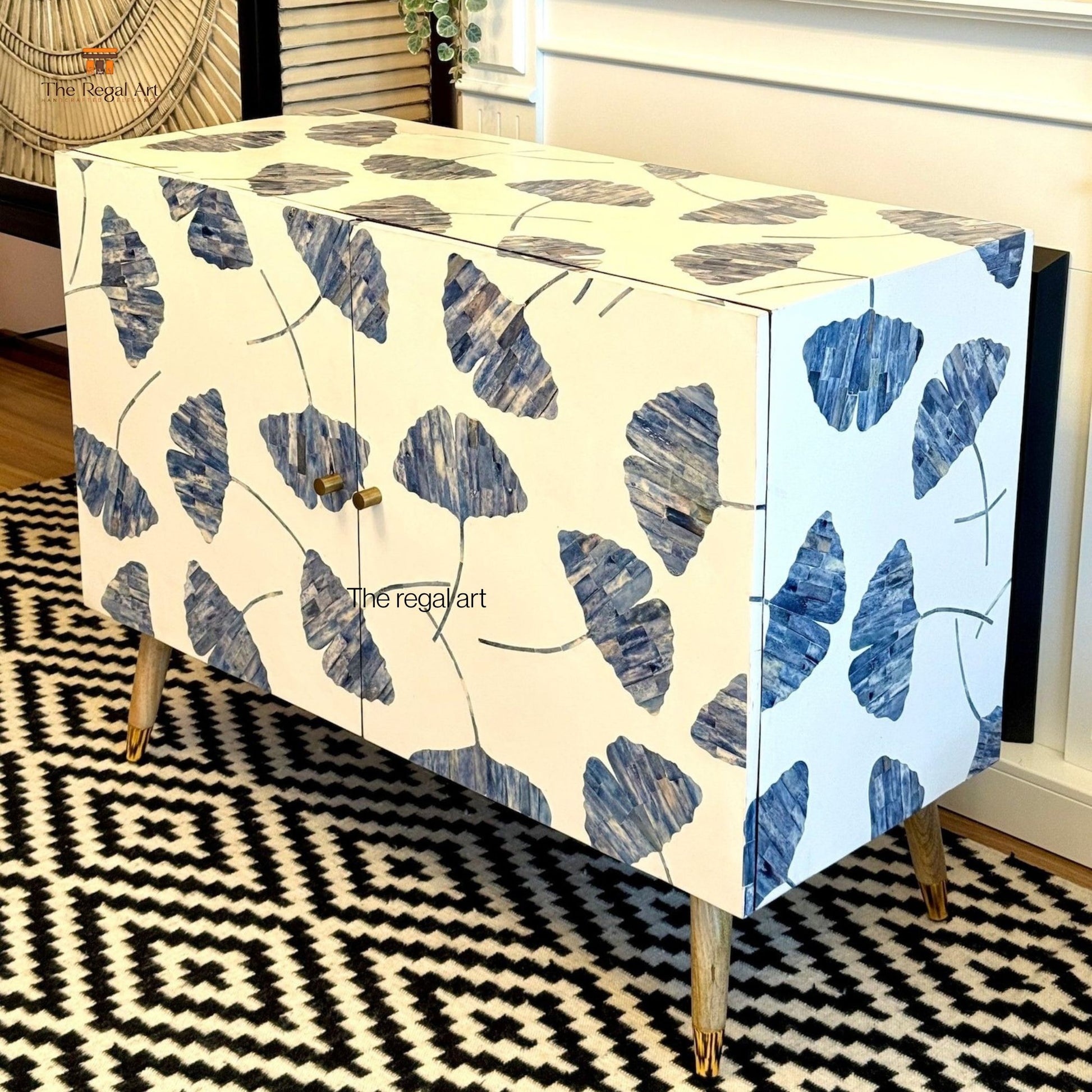 Cabinet with blue leaf pattern on a black and white geometric rug