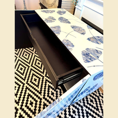 Dining table with a blue and white patterned tablecloth on a geometric rug.