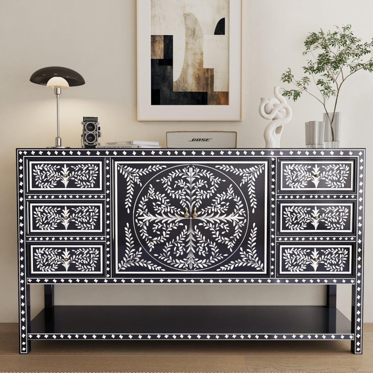 Decorative black and white console table with intricate patterns in a room setting. the regal art