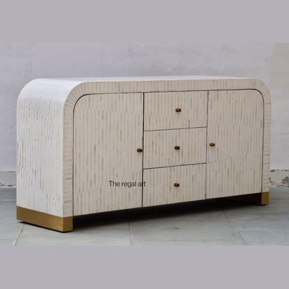 Beige sideboard with gold accents on a gray floor and light gray wall