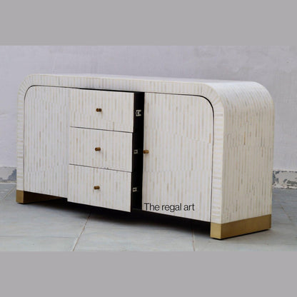 Decorative cabinet with a textured finish and gold accents on a neutral background