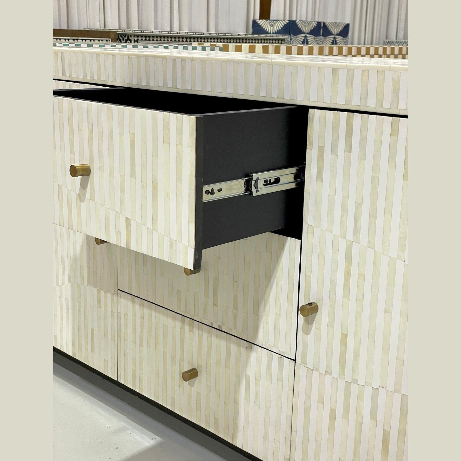 Close-up of a decorative cabinet with a patterned design and black drawer.