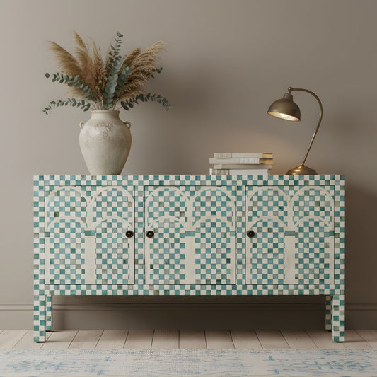Decorative cabinet with mosaic pattern, vase with plants, and lamp on a wooden floor.